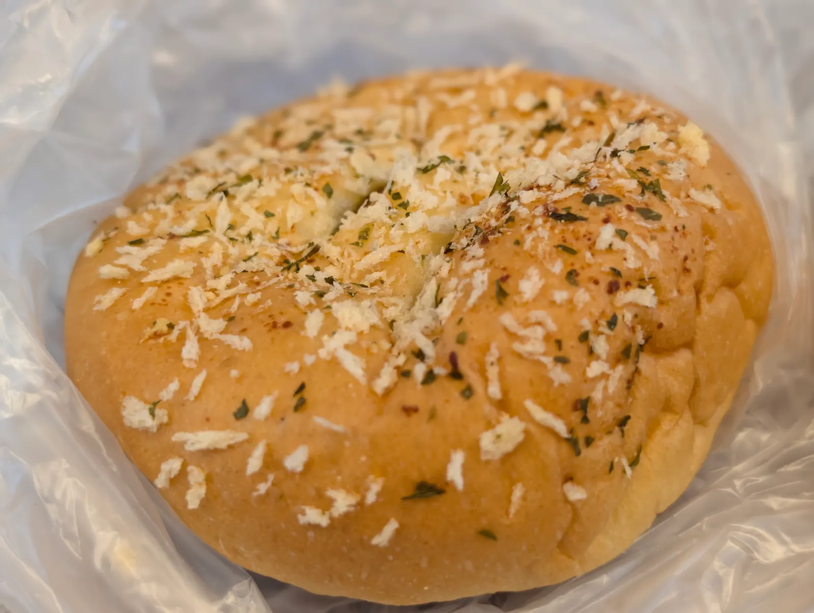 細かなパン粉やハーブのようなトッピングがのった惣菜パン