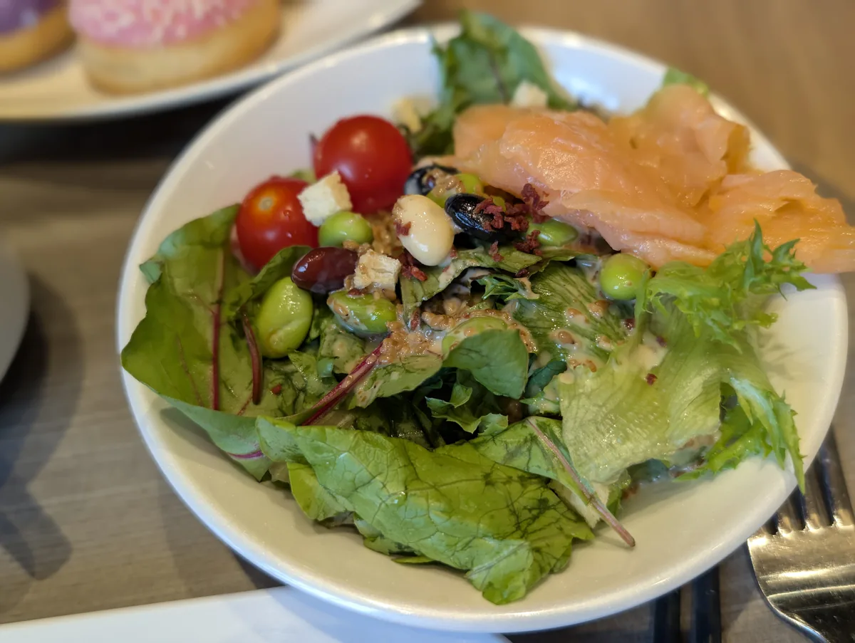 葉物野菜、トマト、豆、サーモンなどを盛り付けたサラダ。外食が続く旅行中に野菜を取りやすいのは助かります。